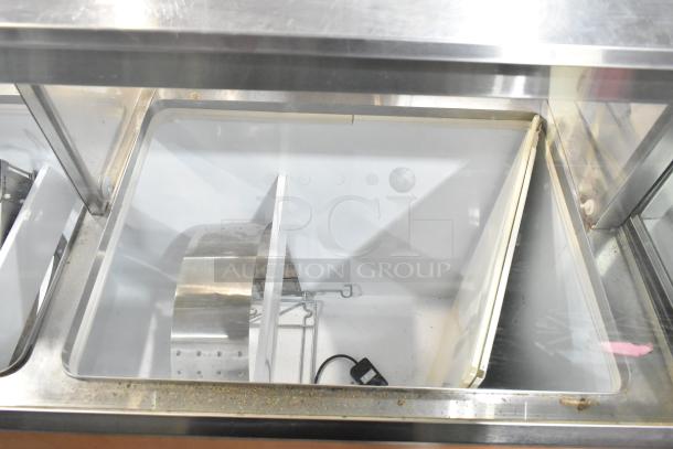 Commercial ice cream dipping cabinet with metal tub collars, 115 volts, 1 phase. Stainless steel construction, inside view.