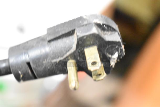 Black electrical plug for a commercial ice cream dipping cabinet, 115 volts, 1 phase.