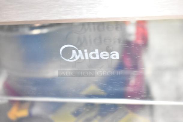 Midea MRV115S1BST mini beverage cooler, 3.3 cu. ft., brand logo visible on glass. 115 volts, 1 phase.