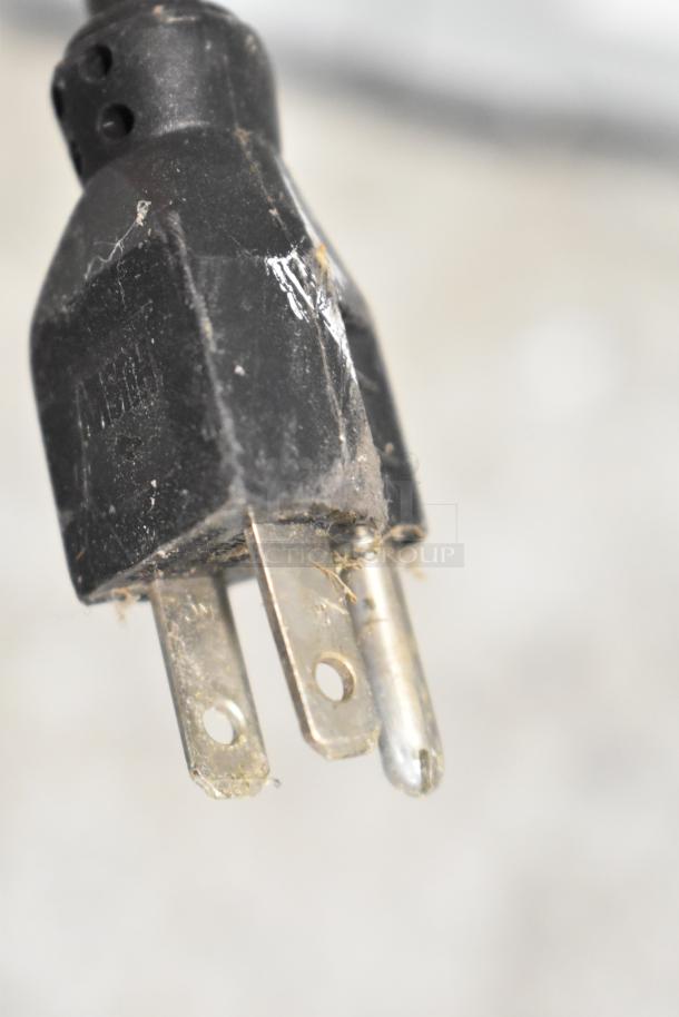 Close-up of a worn electrical plug, likely part of the Suncast C3600G 4 Bay Portable Sink, showing some dirt and minor scratches.