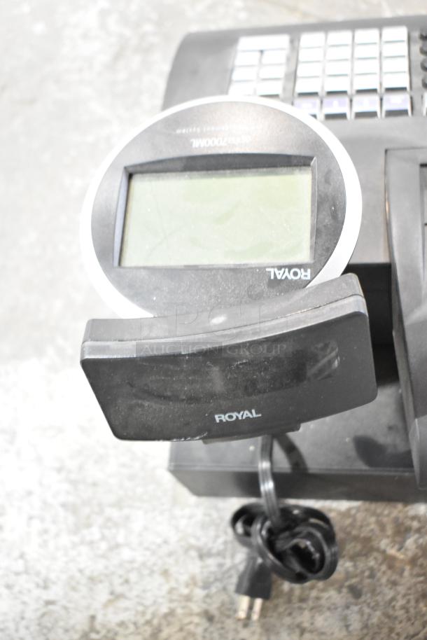 Royal alpha 7000ML electronic cash register, countertop model, 115 volts, 1 phase, with display screen and cord visible.
