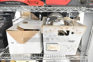 Auction lot including brackets, lid, extension tubes, and hose in cardboard box on metal shelf, good condition.