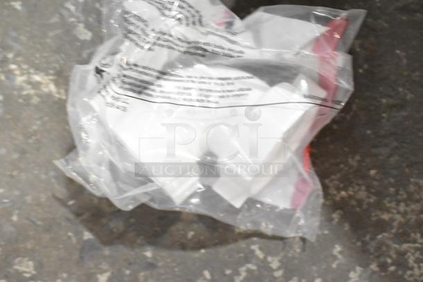 Clear plastic bag containing various items, including white brackets, a lid, extension tubes, and a hose. Items appear unused.