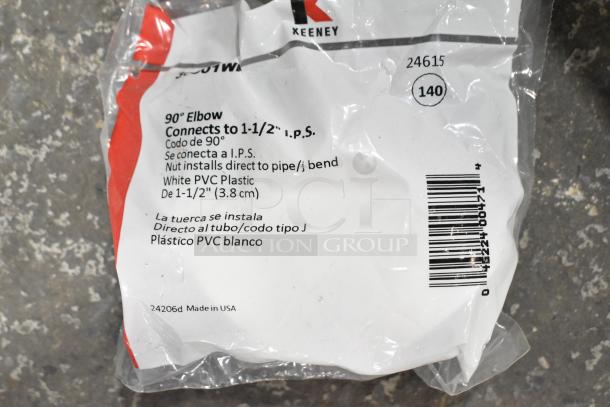 "Image of a Keeney 90° elbow connector in white PVC, 1-1/2 inch size, packaged with labeled instructions and barcode."