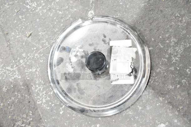 Clear lid with black knob, used condition, has labels and markings, part of a mixed auction lot with brackets and tubing.