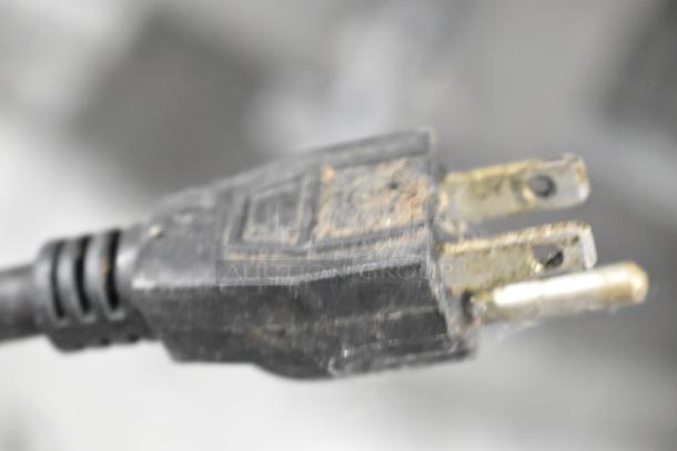 Close-up of a power plug for Avantco 7800 Commercial Countertop Food Warmer. Three-prong plug showing signs of wear.