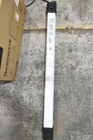 Cooper Lighting 4SHP5040RL light fixture, 120 volts, 1 phase, white and black casing, new condition, on concrete floor.