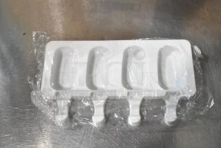 Brand new popsicle molds, white plastic, four cavities, unopened, slight surface scratches, packaged in plastic wrap.