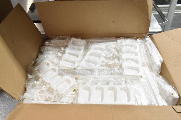 Box of brand new, scratch and dent popsicle molds in clear packaging inside an open cardboard box.