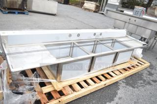 Brand new Regency 600S32424224 commercial 3 bay sink with dual drain boards, minor scratches, on wooden pallet.