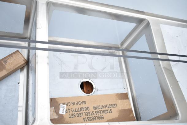 Brand new Regency 600S32424224 commercial 3-bay sink with dual drain boards, scratch and dent condition, visible packaging.