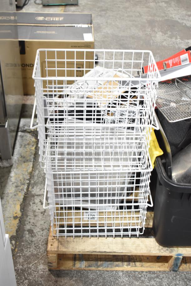 Pallet lot with white wire baskets, metal pans, and cylindrical drop-in bins. Various items stacked on a warehouse floor.