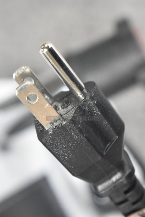 "Commercial steam milk frother power plug, close-up view, brand new with minor scratch and dent imperfections."