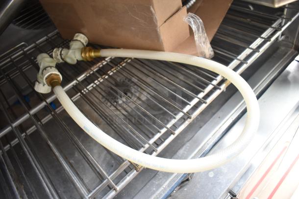 Hydro connection hose inside a Blodgett HVH-100E commercial convection oven, showing interior wire racks and packaging.