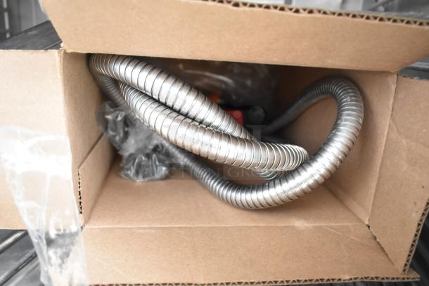 Coiled metal hose and parts inside a cardboard box, part of a Blodgett HVH-100E HydroVection oven packaging.