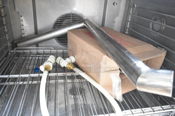 2 new Blodgett HVH-100E convection ovens, 208V, 3-phase. Includes hoods, visible hoses, and parts. Scratch and dent condition.