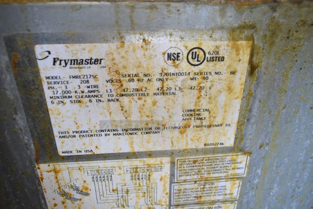 Frymaster FMRE217SC commercial fryer label, showing model, serial number, power specs, and compliance logos. Rust visible.