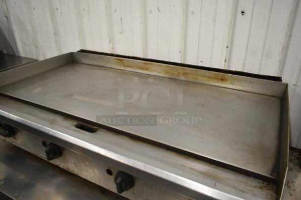 Commercial countertop gas flat top griddle, used condition, stainless steel surface, adjustable heat controls.