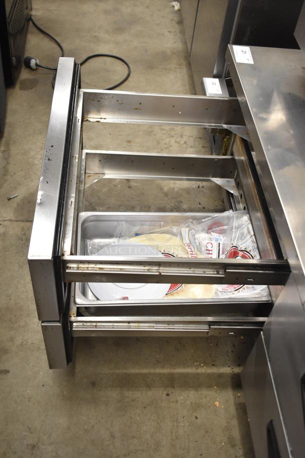 Padela Commercial 4 Drawer Chef Base with casters. Features 115 volts, 1 phase. Visible wear and contents inside drawers.