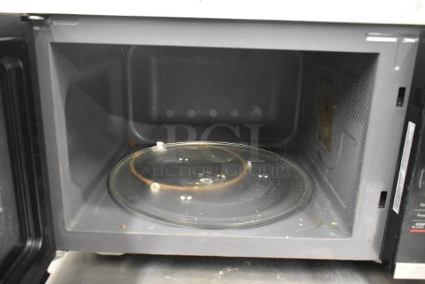 Magic Chef HMM1611ST2 microwave interior view with glass plate, showing used condition. 1.6 cu. ft., 120 volts.