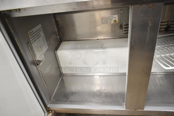 Cooler Depot UUC-72R-E-HC undercounter cooler interior, stainless steel shelving with warning labels. Commercial casters, 115V.