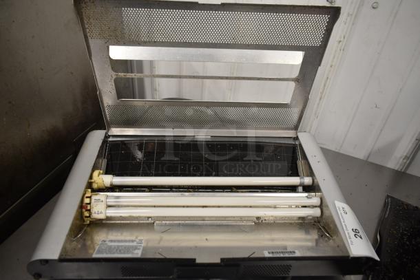 Bag Zapper, 115 Volts, 1 Phase. Metal frame with grid and bar features. Used condition, some visible debris. Identification label on side.