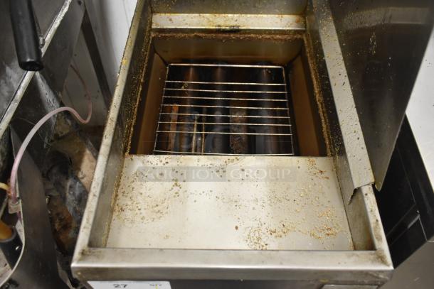 Pitco Frialator commercial deep fat fryer with metal fry baskets on casters. Visible used condition, interior grease buildup.