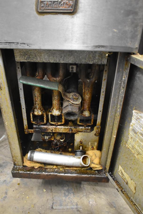 Pitco Frialator commercial deep fat fryer, floor style, with visible internal components, on casters. Condition: worn.