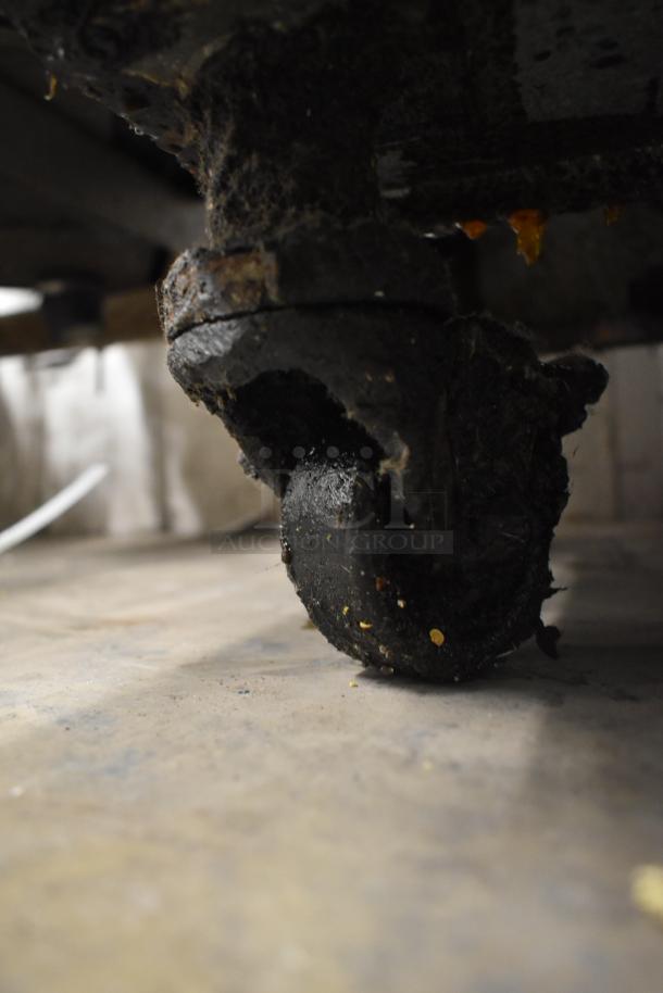 Pitco Frialator commercial fryer caster wheel, showing worn condition and grease accumulation.