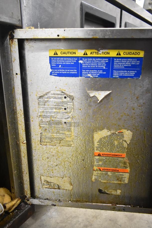 Pitco Frialator commercial deep fat fryer with two metal fry baskets on casters. Visible caution labels on the side.