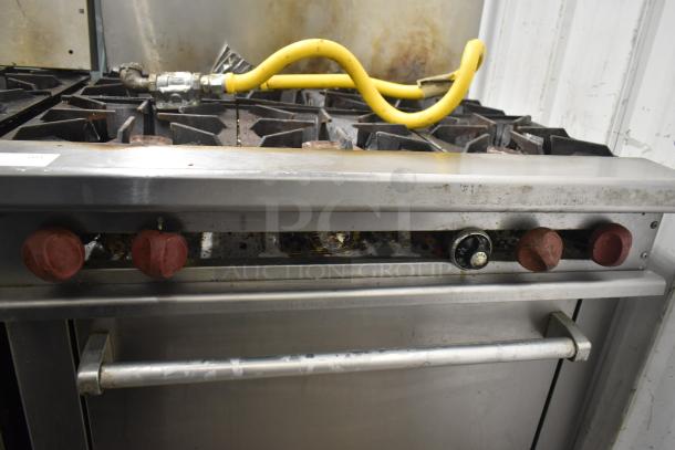 Therma-tek TMD36-6-1N commercial 6 burner gas range with oven, visible wear, yellow gas hose, red control knobs.