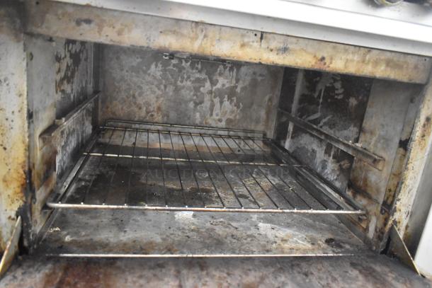 Therma-tek TMD36-6-1N commercial oven interior, showing signs of heavy use and wear. Features include wire rack and metal interior.