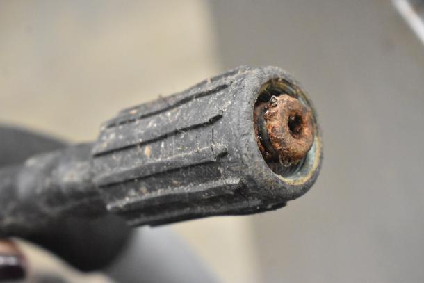 Close-up of a Ryobi 2.3 GPM Pressure Washer nozzle, showing rust and wear on the metal connector.
