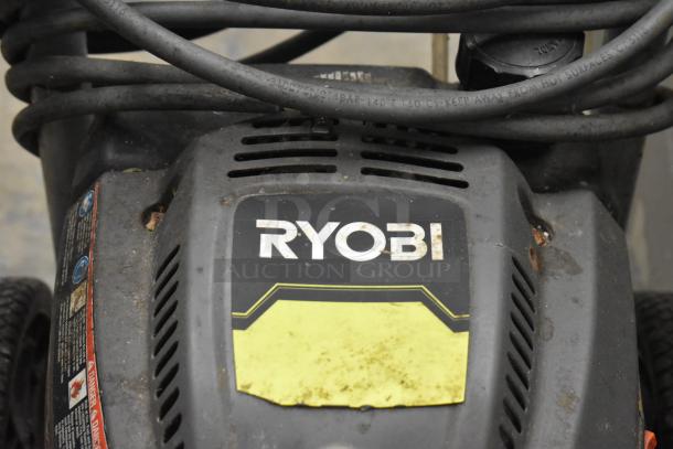 Ryobi 2.3 GPM Pressure Washer, used condition, visible Ryobi branding, rugged design, tangled hose on top.