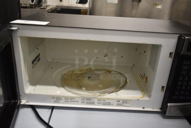 General Electric GE Profile PEM31SM4SS Microwave Oven with plate. Visible wear and stains inside. 120 volts, 1 phase.