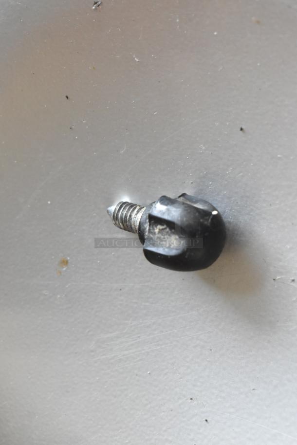 A black knob with attached screw, likely a component for assembly or repair. Slightly worn with visible scratches.