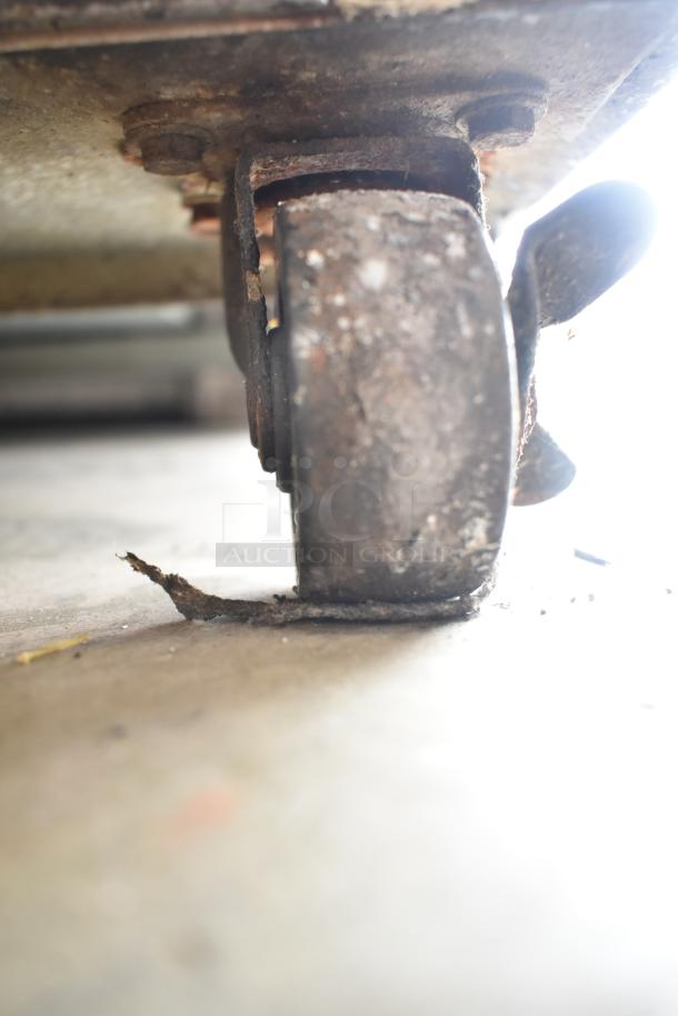 Close-up of a commercial caster from a Yukon YUC-60F undercounter freezer, showing wear and rust.