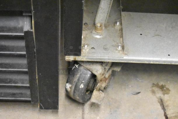 Beverage Air MMR49HC-1-B cooler base detail showing a caster and lower edge, indicative of durable construction.