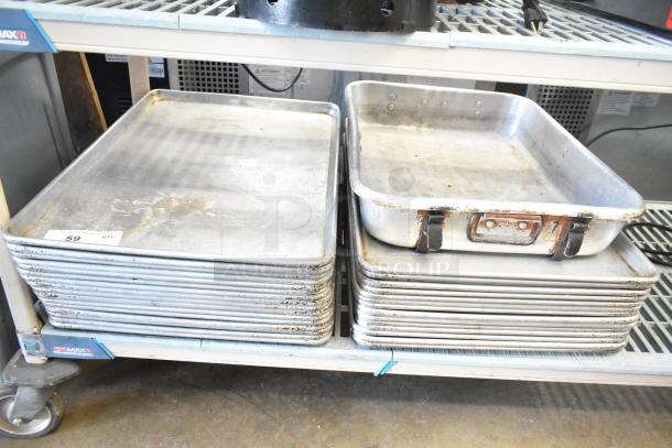 31 baking and roasting pans, metal, used, stacked on a shelf. Some pans show signs of wear and rust. Quantity labeled as 31.