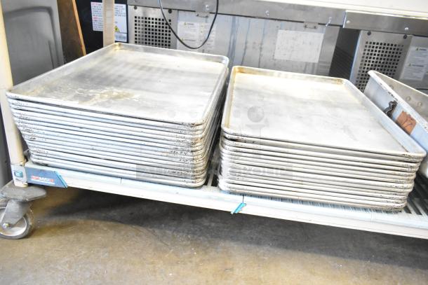 Set of 31 stainless steel baking and roasting pans, full size, used condition, visible wear, great bulk auction value.