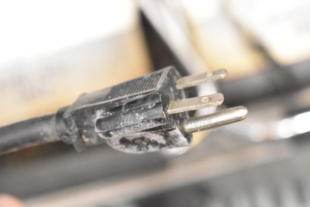Close-up of the power plug of a Vollrath TSI8002 40796 Commercial Countertop Double Panini Press, showing signs of wear.