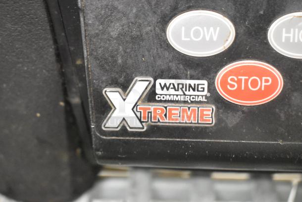 Waring MX1100XTX blender base, black with buttons labeled "LOW," "HIGH," "STOP," and "XTREME." Model and brand markings visible.