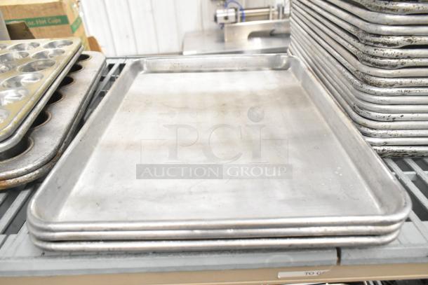 Stack of baking pans and muffin pans, metal, in used condition. Bulk auction of 38 items including bowls and colanders.