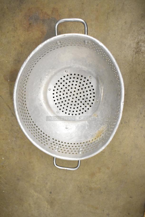 Antique metal colander with handles, showing signs of wear. Part of a 38-piece kitchenware set, auction item.