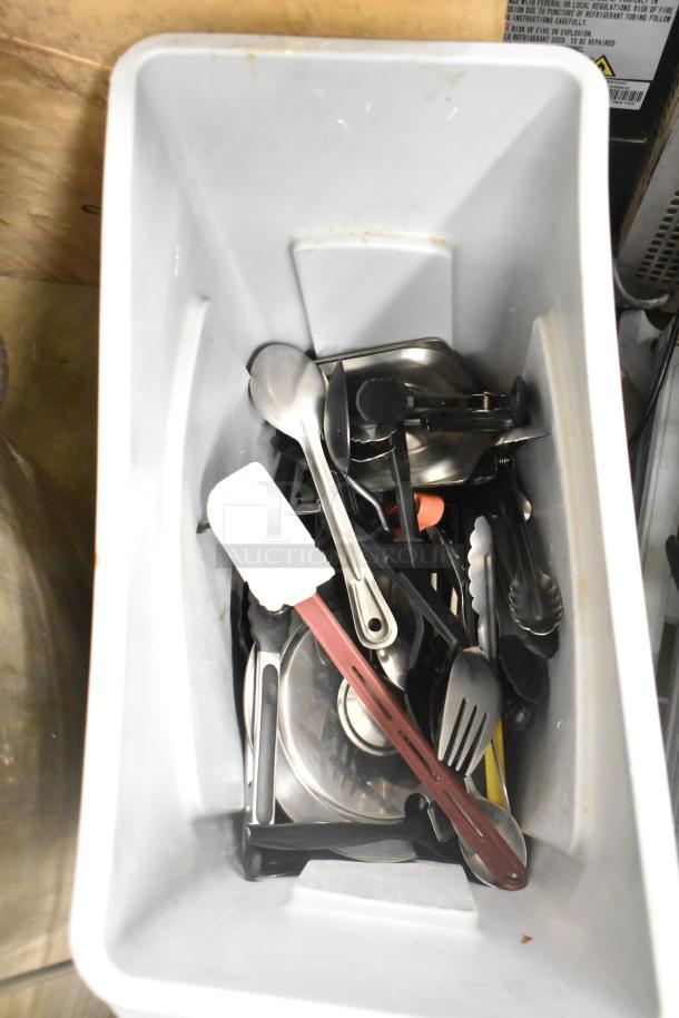 Rubbermaid Brute gray Slim Jim trash can containing tongs, serving spoons, and kitchen utensils. Lightly used condition.