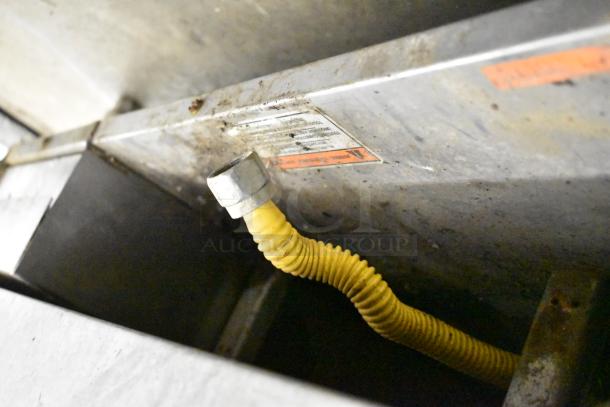 MagiKitch'n Commercial Countertop Flat Top Griddle underside, with visible yellow gas hose and labels. Some wear evident.