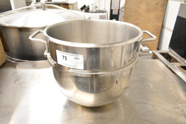 Stainless steel commercial mixing bowl with dual handles and visible auction label. Used condition.
