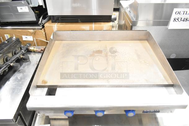 Imperial commercial countertop gas flat top griddle. Stainless steel, 3 knobs, visible wear. Ideal for kitchens.