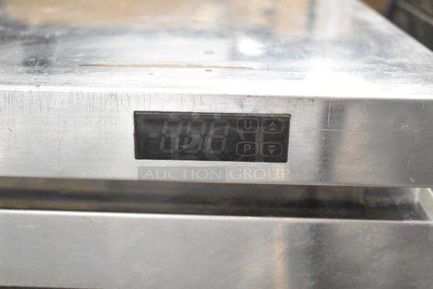 Turbo Air TUR-72SD-D6-N cooler display panel showing temperature. Stainless steel surface with visible scratches.