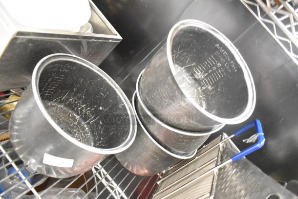 Metro Lot of various kitchen items including metal rice cooker inserts, plastic drop-in bins, and poly pitchers. No shelving.